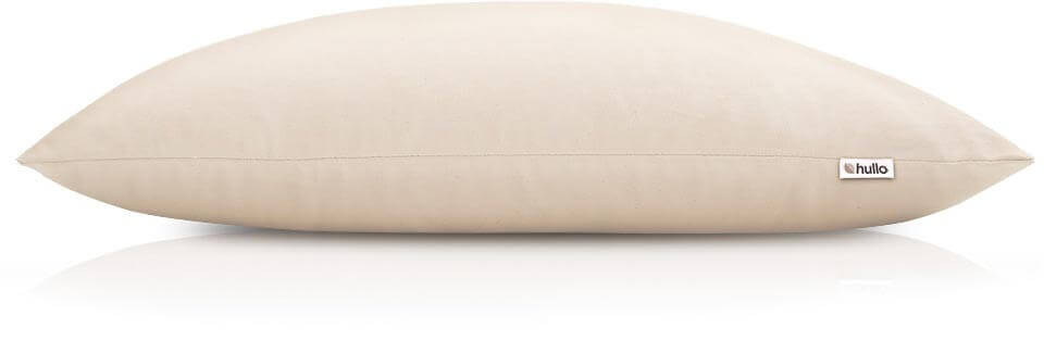 A rectangular beige pillow with a smooth, plain surface is shown. The pillow has a small white tag on one side with the brand name "hullo" printed on it, perfect for any Hullo Pillow Review. The background is white.
