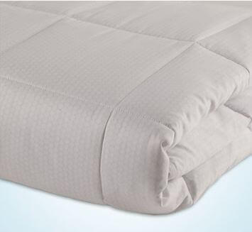 A neatly folded, light gray duvet or comforter with a quilted pattern is displayed against a light background. The fabric appears soft and slightly textured, with the quilting creating a grid-like design on the surface, much like the craftsmanship found in a Slumber Cloud mattress pad.