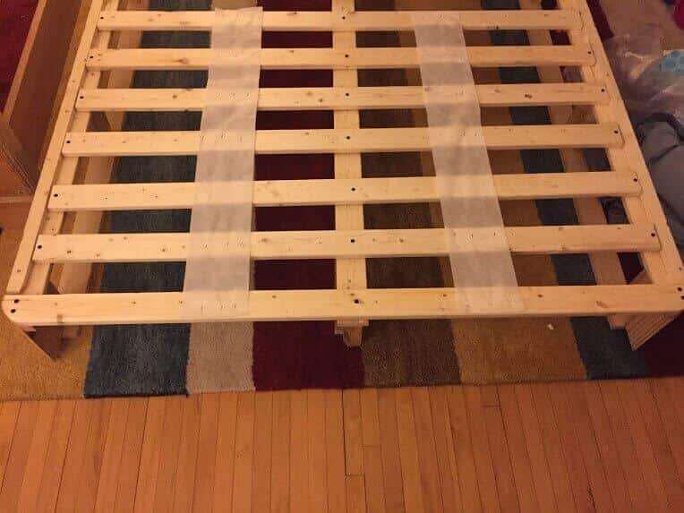 Modern box spring foundation showing wooden slat construction inside a fabric cover
