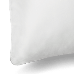 Close-up of a Silk Pillowcase with smooth fabric. The corner of the pillowcase is visible, showcasing clean lines and a minimalist design. The background is plain and non-distracting, emphasizing the pillowcase's simplicity and softness.