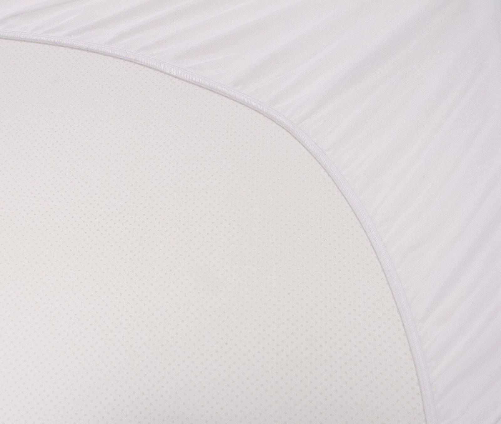 Close-up photo of Solis Quiet Comfort™'s white, curved fabric surface with a slightly textured pattern. The fabric appears to be stretched and smooth, creating a clear division between the curved section and the surrounding area.