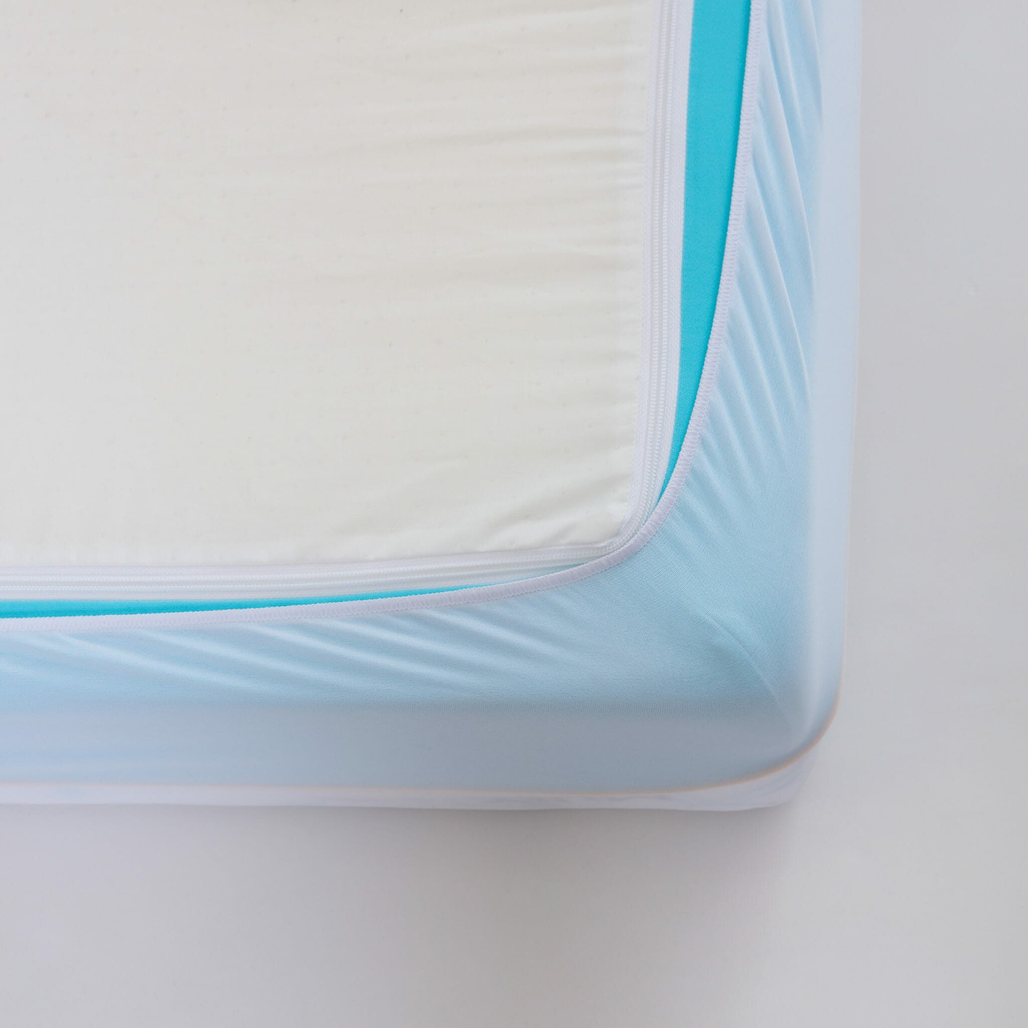 A close-up of a Mlily JAMA 7" Mattress corner showcasing a light blue mattress cover with a zippered edge. The cover appears tightly fitted around the mattress, emphasizing its snug and secure fit.
