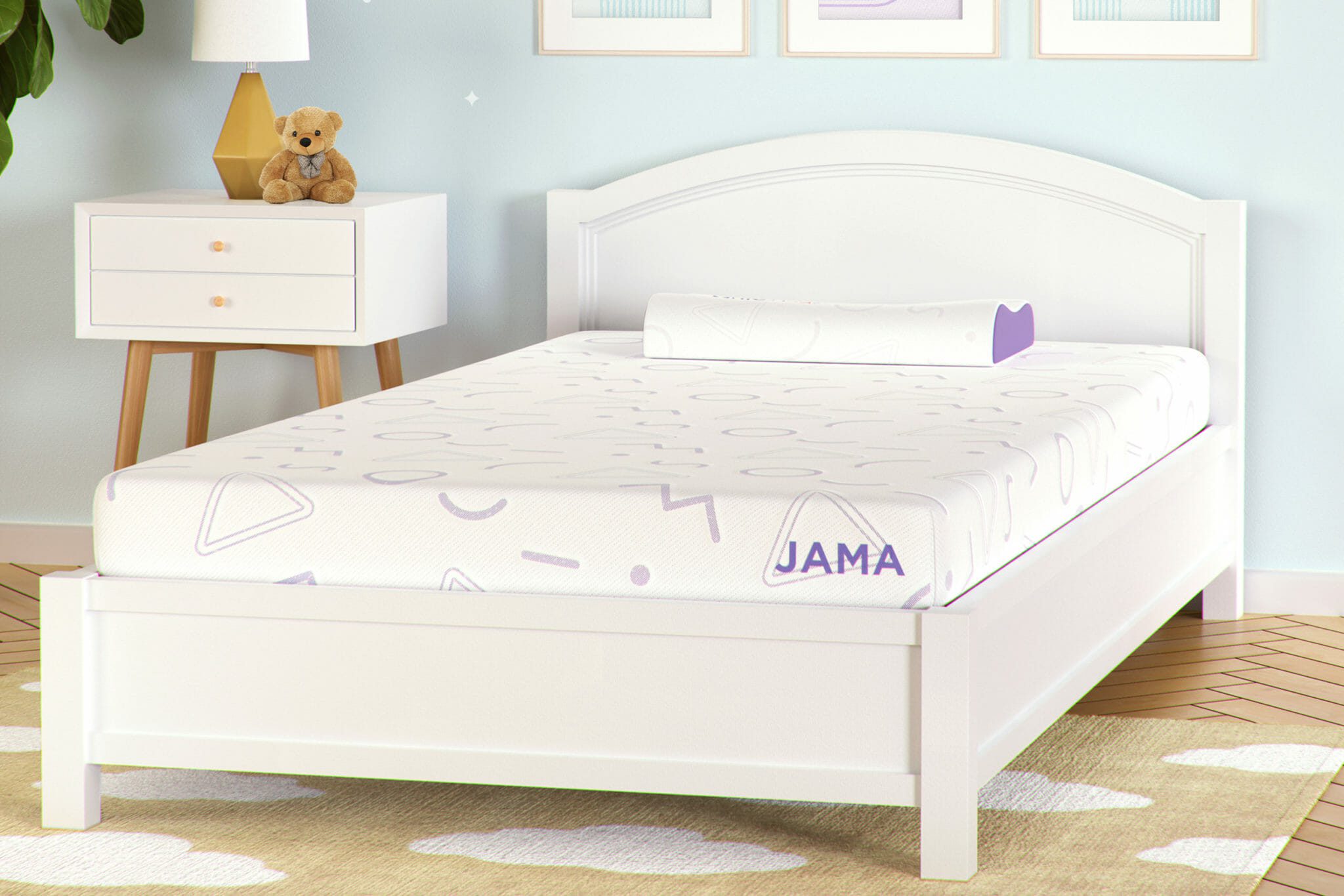 A child-sized white bed with a Mlily JAMA 5" Mattress is set in a light-colored room with light blue walls. A white, two-drawer nightstand sits next to the bed, topped with a lamp and a teddy bear. The floor features a beige rug with white cloud patterns.