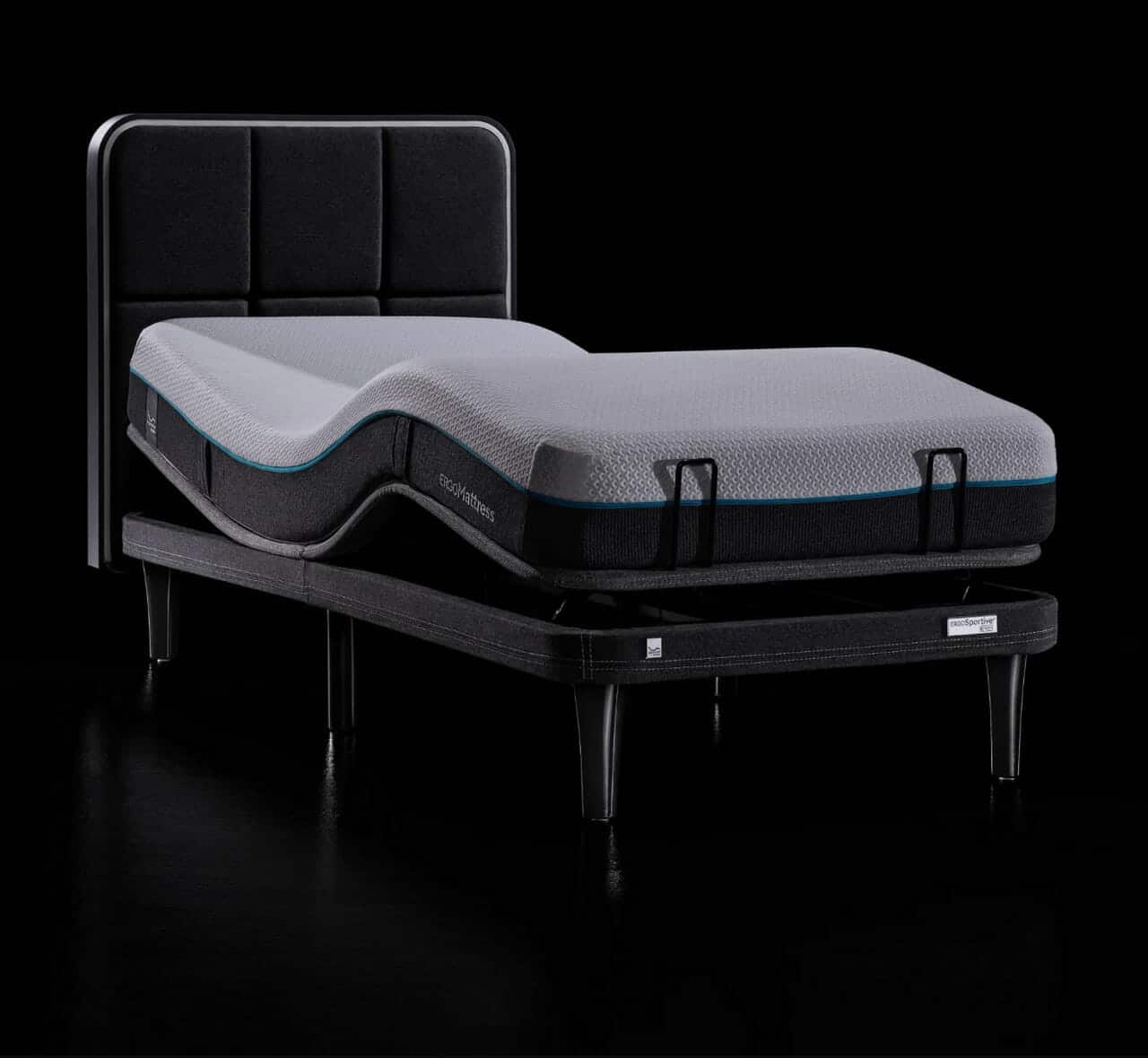 The Ergo Sportive Adjustable Smart Bed, featuring a sleek black frame and headboard, is displayed against a black background. The mattress showcases a white top with segmented dark trim and is supported by four sturdy legs. The mattress appears articulated in a raised position.