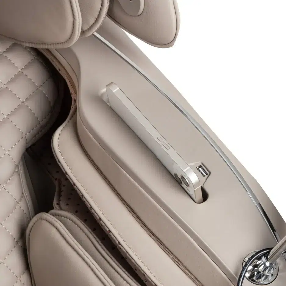 The Osaki Platinum Solis 4D+ luxury car seat in a quilted beige leather design features an integrated center console holder, elegantly housing a slim smartphone. This setup showcases sleek and sophisticated design elements, exuding modernity throughout the car's interior.