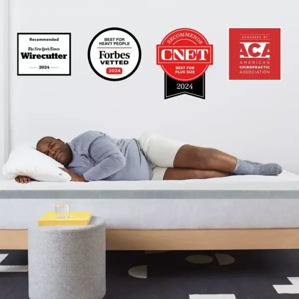 A person relaxes on the Helix Plus, a bed featuring a gray frame and white mattress, dressed in a gray long-sleeve top and shorts. Displayed in the background are four award badges from Wirecutter, Forbes Vetted, CNET, and the American Chiropractic Association.