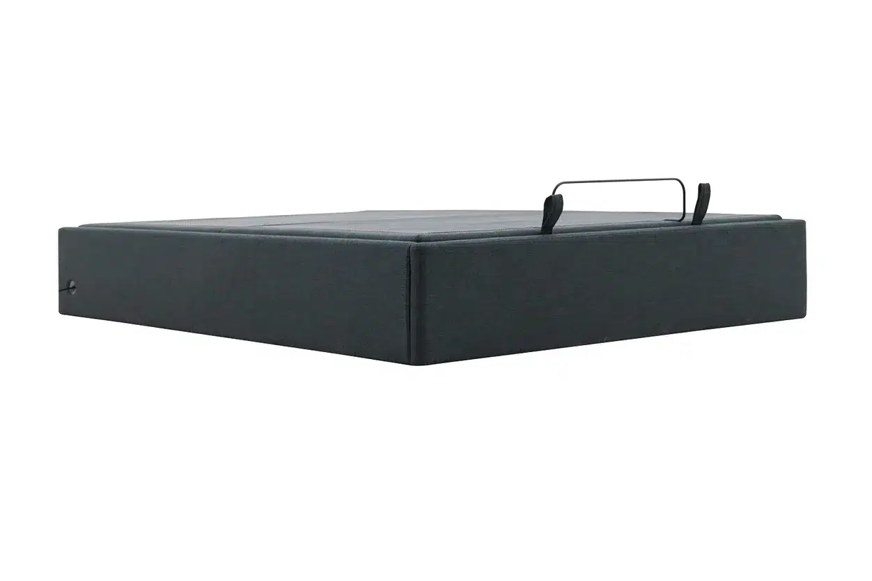 The STOW Storage Adjustable Base is a gray, box-like object with a soft texture and equipped with a black metal handle on the top. It boasts a minimalist design that emphasizes simplicity and functionality.