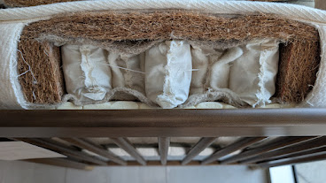 Close-up of the pocketed coil and coir layer inside the Avocado Luxury Organic Crib Mattress