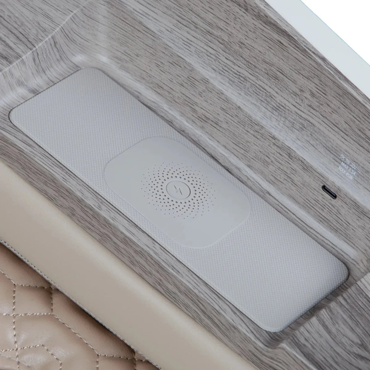 Built-in wireless phone charging pad in the armrest