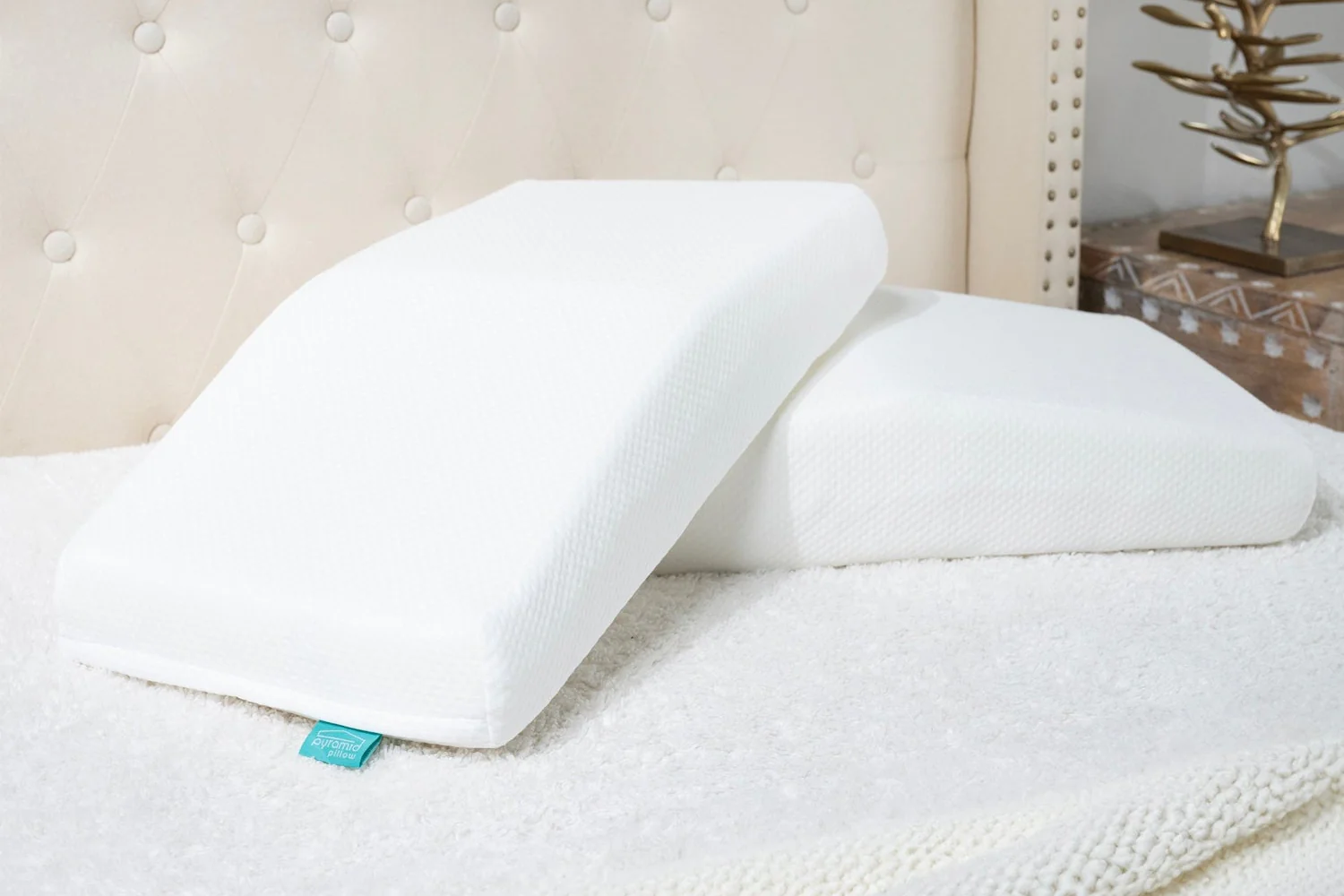 Two Pyramid Pillows stacked on a bed showing the wedge profile